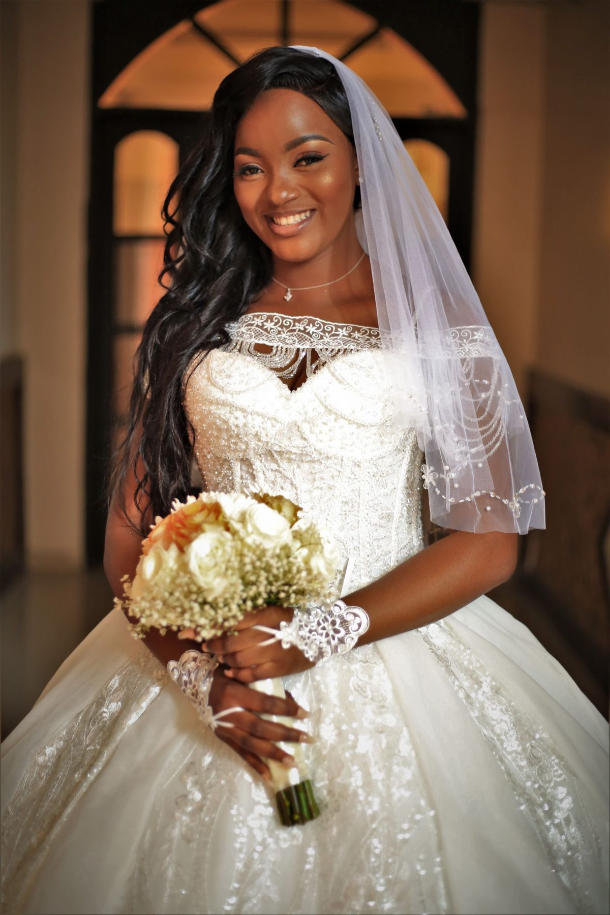 Elegant bride in a warm-toned gown with luxurious destination wedding makeup